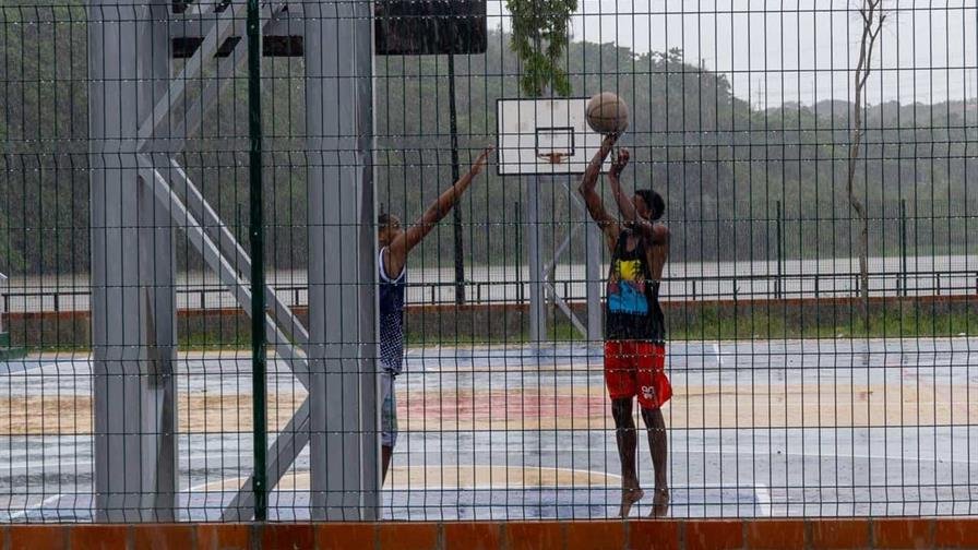 Niños juegan en las calles y se bañan bajo la lluvias tras la tormenta